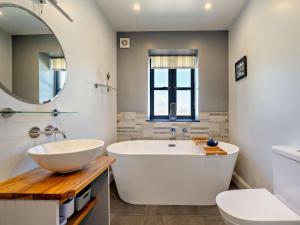 a bathroom with a large tub and a mirror at 2 Bed in Belford oc-92196 in Ellington +15 photos