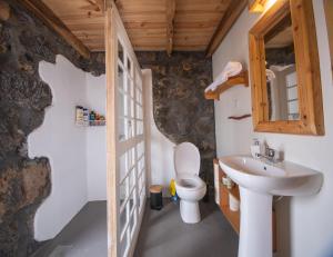 a bathroom with a toilet and a sink at Ribeirinha 94 in Ribeirinha +14 photos