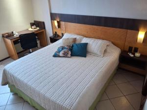 a bedroom with a large bed with a wooden headboard at Um lar aconchegante na rota do sol in Natal