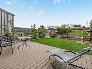 a wooden deck with a table and chairs on it at 1 Bed in Leeds oc-89862 in Sherburn in Elmet