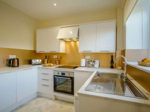a kitchen with white cabinets and a sink at 2 Bed in Mindrum oc-85422 in Carham