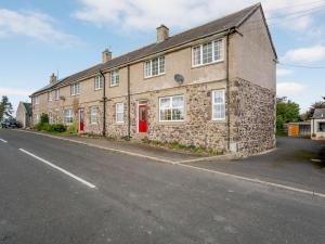 a brick building with red doors on a street at 2 Bed in Mindrum oc-85422 in Carham