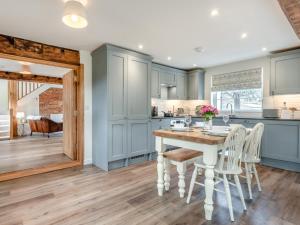 a kitchen with blue cabinets and a table and chairs at 2 Bed in Fordingbridge oc-96127 in Godshill