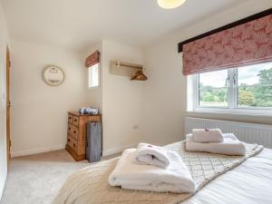 a bedroom with a bed with two towels on it at 2 Bed in Fordingbridge oc-96127 in Godshill