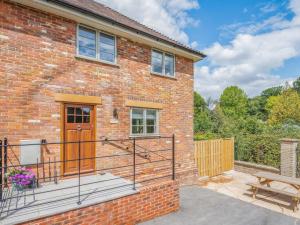 a brick house with a wooden door and a bench at 2 Bed in Fordingbridge oc-96127 in Godshill