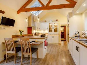 a kitchen with white cabinets and a table with chairs at 1 Bed in Chard oc-91135 in Cudworth