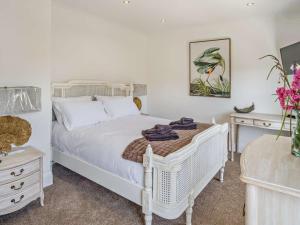 a bedroom with a white bed and two night stands at 3 Bed in Shanklin oc-92052 in Shanklin