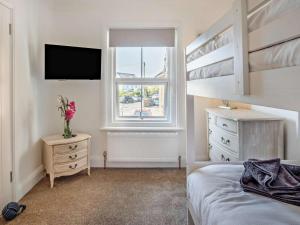 a bedroom with a bed and a dresser and a window at 3 Bed in Shanklin oc-92052 in Shanklin