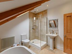 a bathroom with a shower and a toilet and a sink at 3 Bed in Morpeth oc-61257 in Harbottle +23 photos