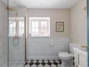 a white bathroom with a shower and a toilet at 5 Bed in Lymington oc-96189 in Sway +24 photos