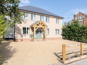 a large white house with a green door at 5 Bed in Lymington oc-96189 in Sway