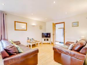a living room with two leather couches and a television at 3 Bed in Wareham oc-dc157 in Stoborough