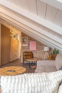a living room with a couch and a brick wall at Eggstätt am Chiemsee, Auto-Check-in 24-7, gratis Parkplatz an der Unterkunft, Netflix & Amazon Prime inc, voll ausgestattet in Eggstätt