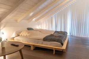 a large bed in a room with a table at Eggstätt am Chiemsee, Auto-Check-in 24-7, gratis Parkplatz an der Unterkunft, Netflix & Amazon Prime inc, voll ausgestattet in Eggstätt