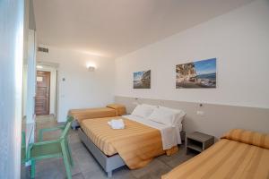 ein Schlafzimmer mit zwei Betten und einem Stuhl in der Unterkunft Hotel Ispinigoli in Dorgali