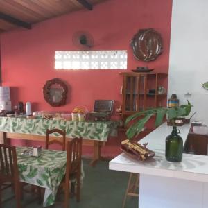 a kitchen with red walls and a table with chairs at Hotel D'Aldeia Cametá in Cametá