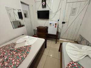 a room with two beds and a tv in it at Hotel D'Aldeia Cametá in Cametá