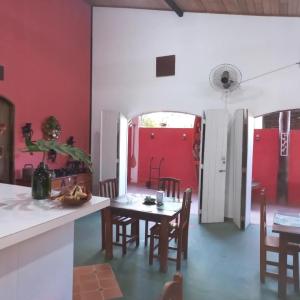 a kitchen with red walls and a table and chairs at Hotel D'Aldeia Cametá in Cametá +4 photos