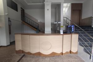 a large wooden counter in a building with stairs at Indraprastha Executive Lodging in Pune