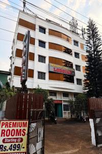 a large white building with a sign in front of it at Indraprastha Executive Lodging in Pune