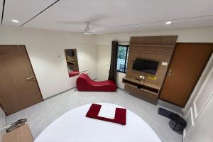 a room with a table and a red chair at Indraprastha Executive Lodging in Pune