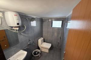 a small bathroom with a toilet and a sink at Indraprastha Executive Lodging in Pune +11 photos