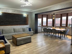 a living room with a couch and a table and chairs at Waterfall home in Yerevan