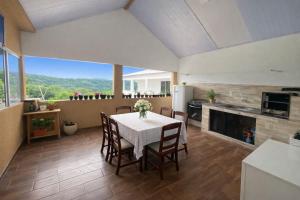 a kitchen and dining room with a table and chairs at Suites Lara Jackson in Saquarema