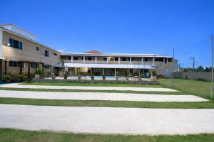 a large building with a pathway in front of it at Suites Lara Jackson in Saquarema