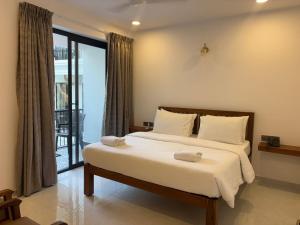 a bedroom with a bed and a large window at Henmil Hideaway in Anjuna +77 photos