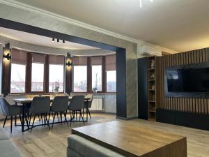 a dining room with a table and chairs and a television at Waterfall home in Yerevan