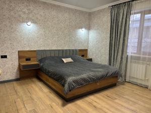 a bedroom with a bed and a large window at Waterfall home in Yerevan