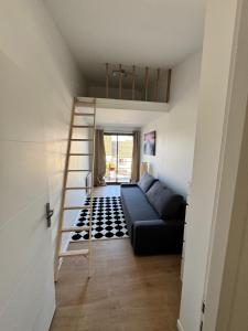 a living room with a couch and a ladder at VILLA Papillon , maison entière avec jardin in Champigny-sur-Marne