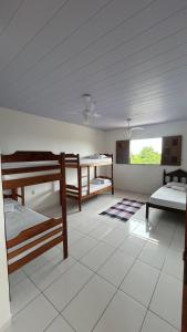 a room with three bunk beds and a window at Pousada Maia in Itaúnas