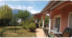 a porch of a house with a table and chairs at Shanaël in Gap