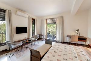 a living room with a television and a table at Anantya At Anamiva in North goa