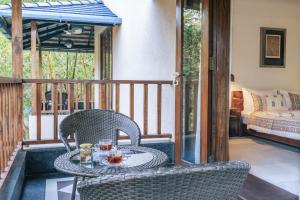 a patio with two chairs and a table on a porch at Anantya At Anamiva in North goa