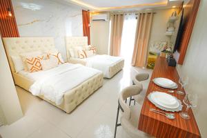 a hotel room with two beds and a table with a dining room at Alpine Villas at Crosswinds Tagaytay Casa de Vela in Tagaytay