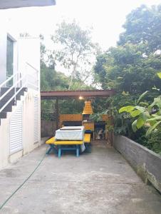 a patio with a table and a bed on it at Suíte do Galo in Arraial do Cabo