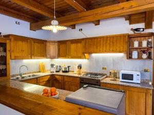 a large kitchen with wooden cabinets and a counter top at Belvedere Solferino panoramic view in Campolongo +25 photos