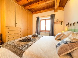 a bedroom with a large bed with towels on it at Belvedere Solferino panoramic view in Campolongo