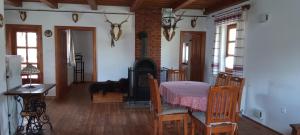 a dining room with a table and a fireplace at Budafai Vendégház in Kiscsehi