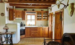 a kitchen with wooden cabinets and a white refrigerator at Budafai Vendégház in Kiscsehi