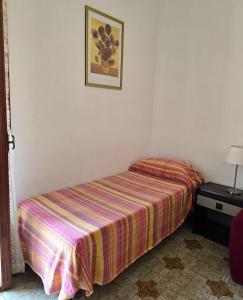 a bed in a room with a striped blanket at Rosa Dei Venti in Amalfi