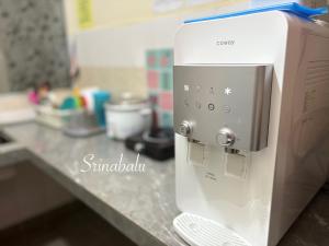 a white microwave sitting on a kitchen counter at Sri Nabalu Apartment Platinum Putatan in Kota Kinabalu