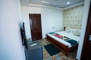 a bedroom with a bed and a television in it at Eastern Plus Hotel in Somanya