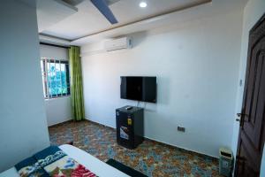a bedroom with a bed and a tv on the wall at Eastern Plus Hotel in Somanya +62 photos