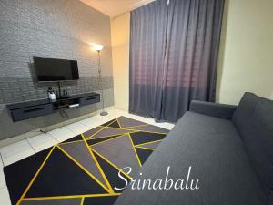 a living room with a couch and a flat screen tv at Sri Nabalu Apartment Platinum Putatan in Kota Kinabalu