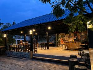a group of people sitting at a restaurant at night at Hillside Hostel & Bungalows in Kaôh Rŭng (3) +27 photos