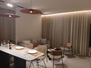 a dining room with a table and chairs and a couch at Amor Club Luxury Suite in Eilat